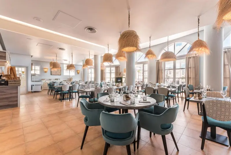 Une salle lumineuse avec des tables et des chaises pour les repas.