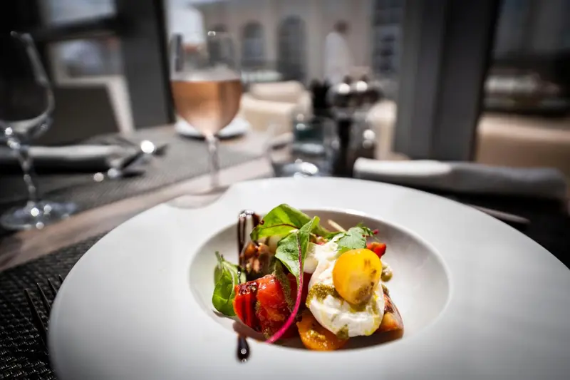 Une assiette de salade garnie d'un œuf au plat est mise en valeur sur une table dressée.