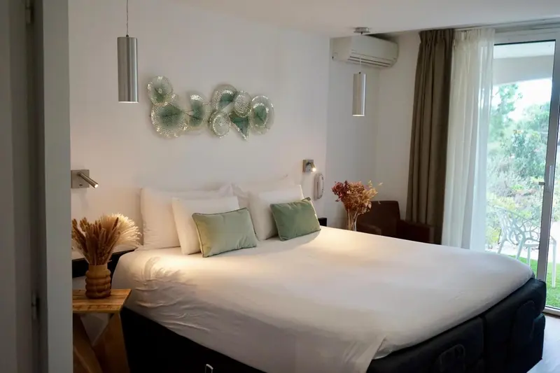 Une chambre lumineuse avec un grand lit recouvert de coussins.