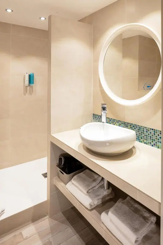 Une salle de bain avec lavabo et miroir lumineux.