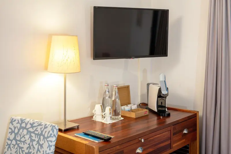 Une chambre lumineuse avec un bureau et une télévision murale.