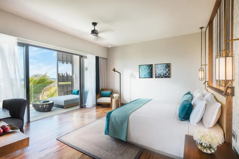 Une chambre lumineuse avec un grand lit et un accès à une terrasse privée.