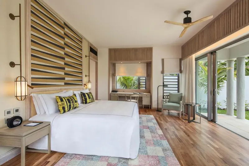 Une chambre lumineuse avec un grand lit et un accès à une terrasse.