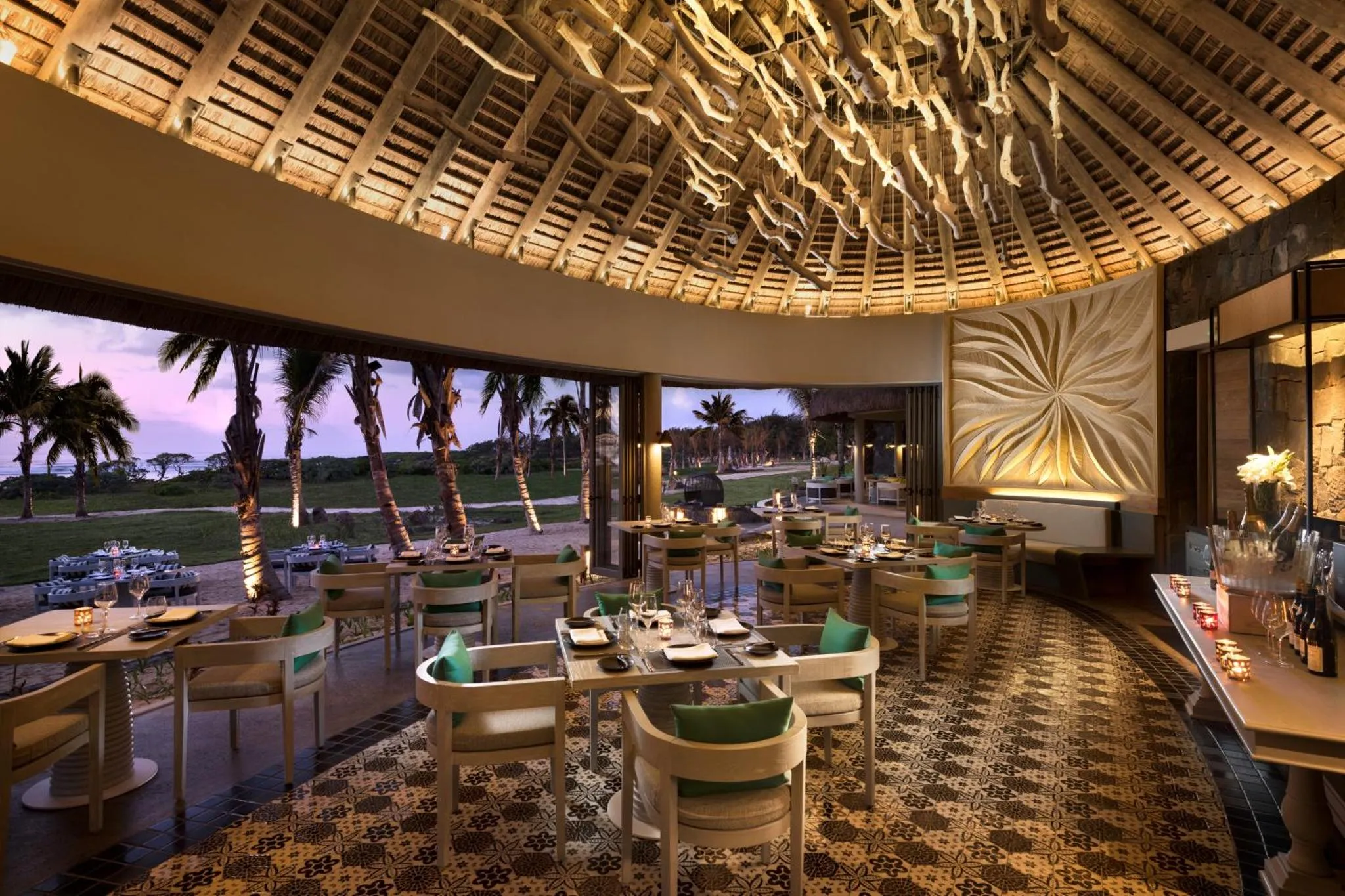 Une salle à manger lumineuse s'ouvre sur une vue sur la plage et les palmiers.