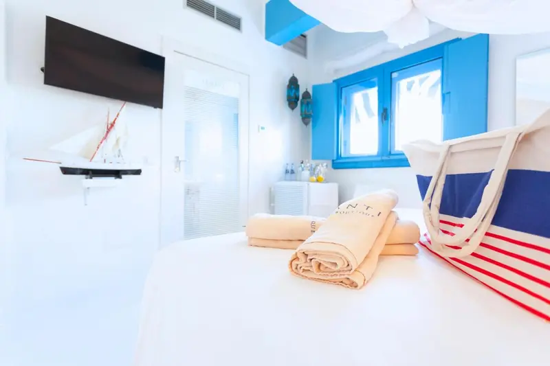 Une chambre lumineuse avec un lit recouvert d'une couverture rayée et des oreillers.