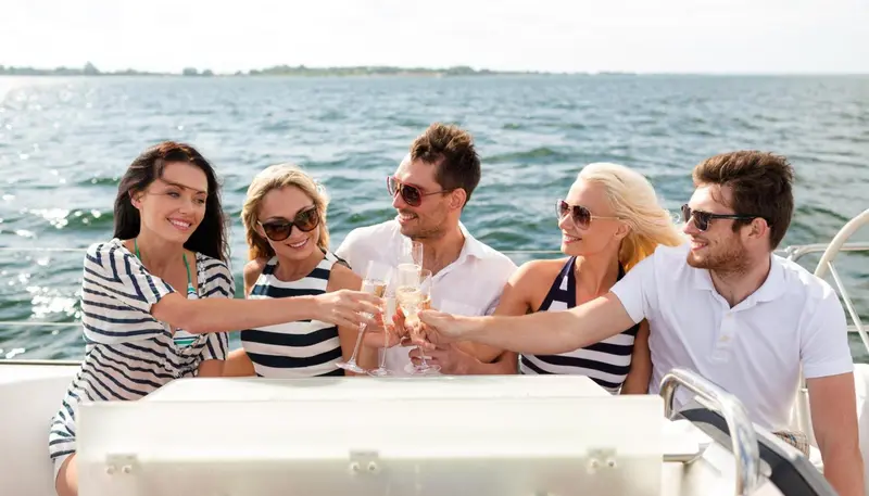 Un groupe de personnes trinque à bord d'un bateau en mer.