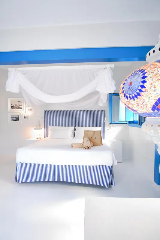 Une chambre lumineuse avec un grand lit à baldaquin et une décoration soignée.