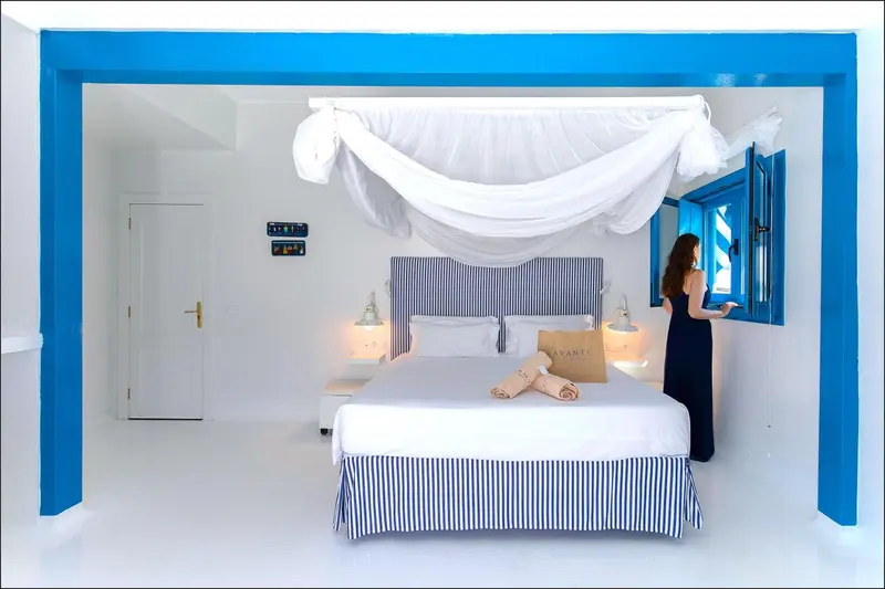 Une chambre lumineuse avec un lit à baldaquin et une fenêtre ouverte.