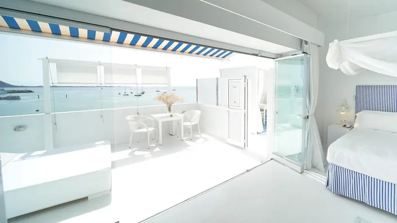 Chambre lumineuse avec vue sur la mer et terrasse aménagée.
