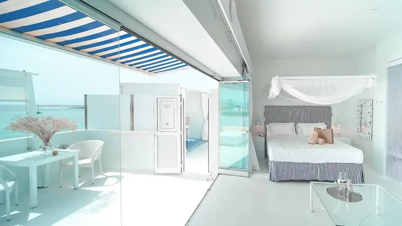 Une chambre lumineuse s'ouvre sur une terrasse avec vue sur la mer.