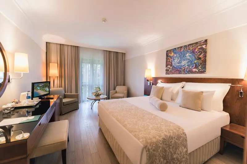 Une chambre lumineuse avec un grand lit et un coin salon.
