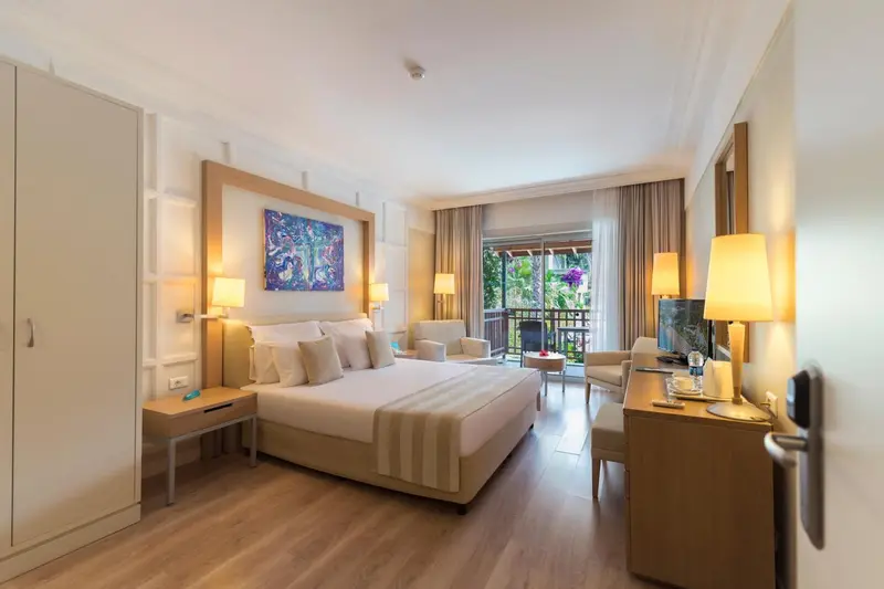 Une chambre lumineuse avec un grand lit et un accès à un balcon.