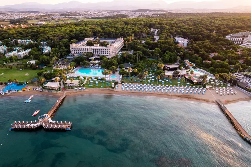 Vue aérienne d'un complexe hôtelier avec piscine et plage.