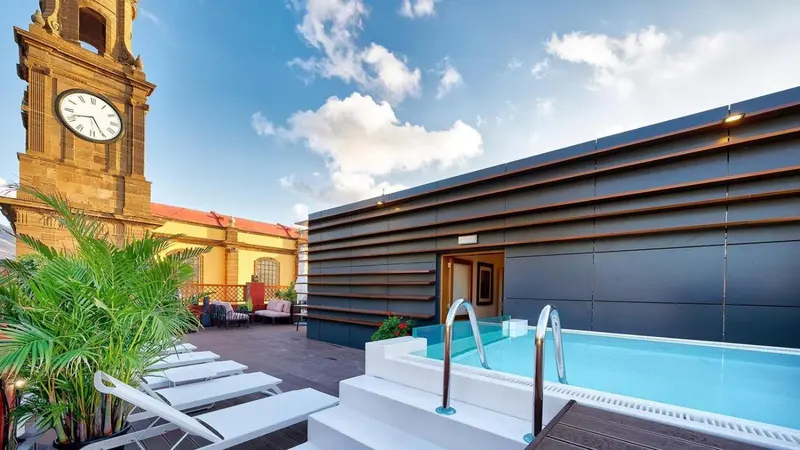 Terrasse aménagée avec transats et petite piscine.