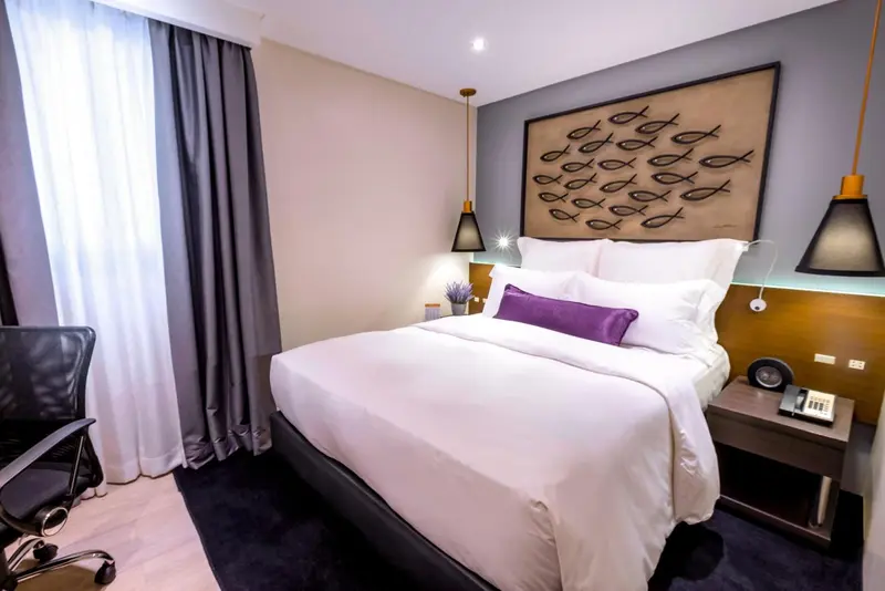 Une chambre avec un grand lit et une décoration murale.