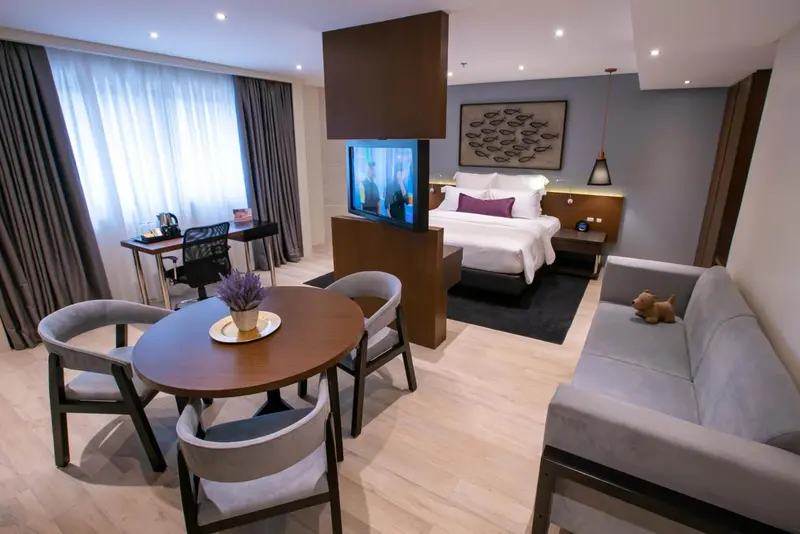 Une chambre lumineuse avec un espace repas et un coin salon.