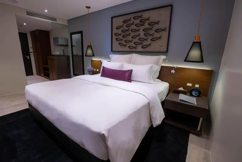 Une chambre d'hôtel moderne avec un grand lit et une décoration sobre.