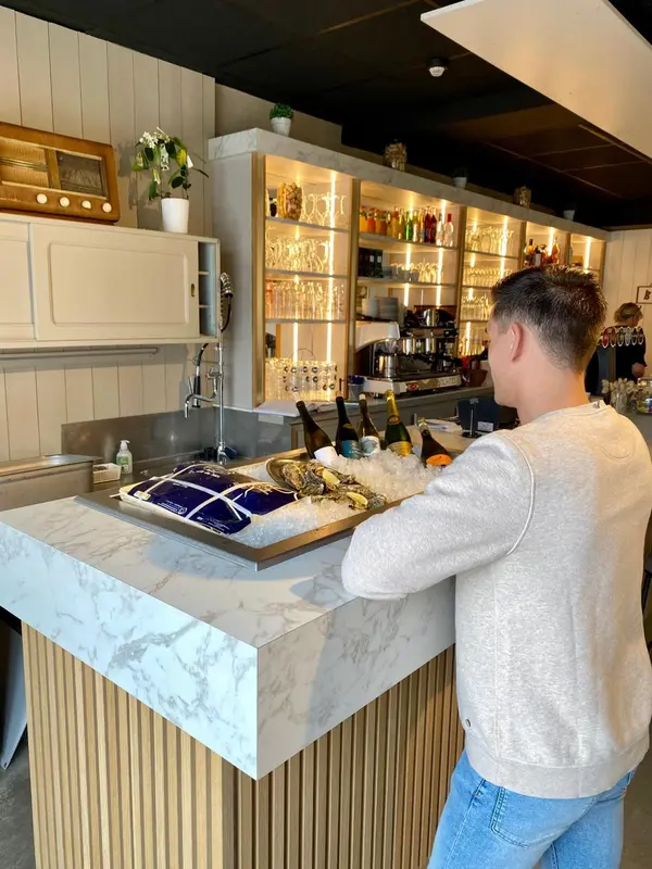 Un comptoir de bar en marbre présente des fruits de mer frais et des boissons.