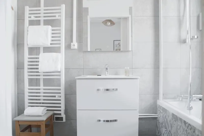 Une salle de bain moderne avec une baignoire et des serviettes blanches.