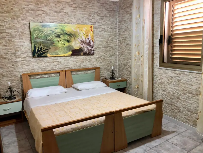 Une chambre avec un lit double et une décoration murale texturée.