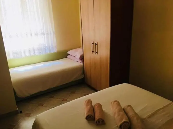 Une chambre avec deux lits simples et une armoire.
