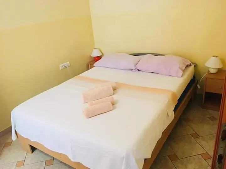 Une chambre lumineuse avec un lit double et des tables de chevet.