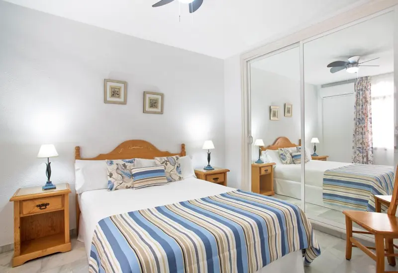 Une chambre lumineuse avec un grand lit et des meubles en bois.