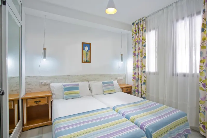 Une chambre lumineuse avec deux lits simples et une décoration florale.