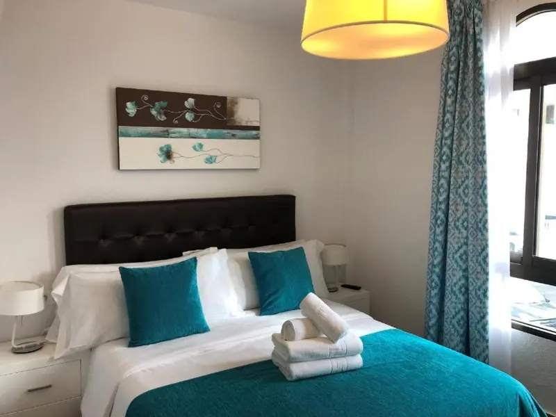 Une chambre à coucher avec un lit double et une décoration turquoise.