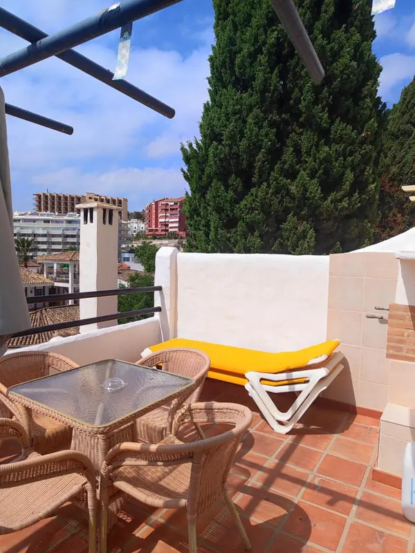 Terrasse avec mobilier de jardin et vue sur la ville.