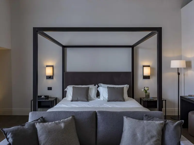 Une chambre avec un grand lit à baldaquin et un canapé.