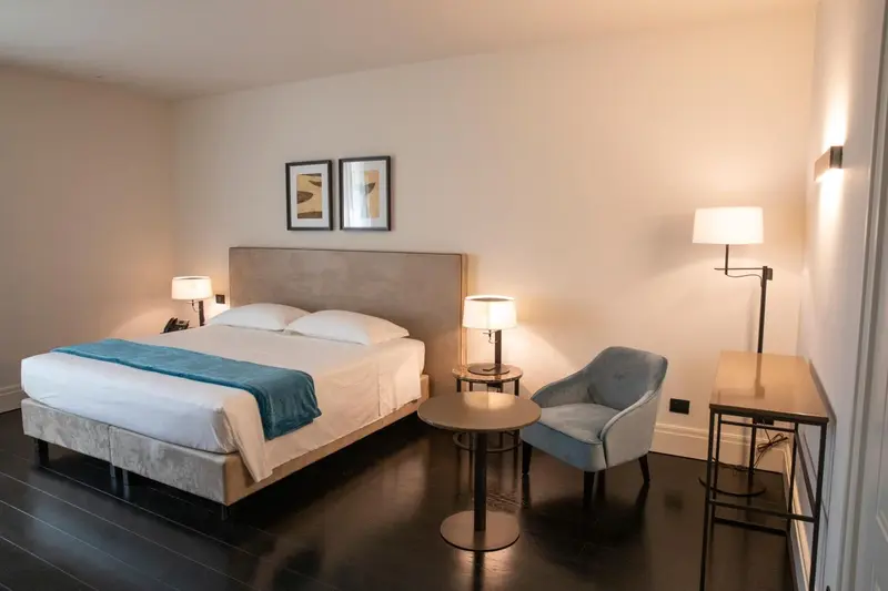Une chambre d'hôtel moderne avec un grand lit et un fauteuil.