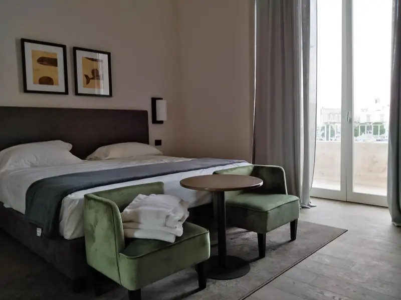Une chambre lumineuse avec un grand lit et un coin salon.