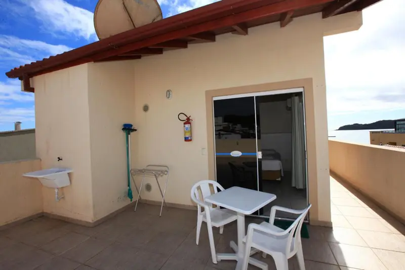 Terrasse avec table et chaises devant une piece interieure.