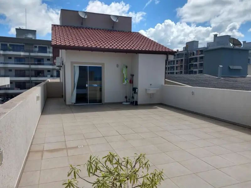 Terrasse carrelée avec mobilier de jardin et accès à une porte vitrée.