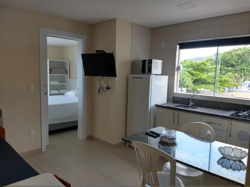 Une kitchenette lumineuse s'ouvre sur une chambre avec lits superposés.