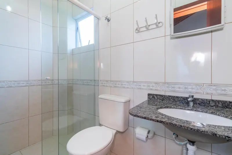 Une salle de bain claire avec douche à l'italienne et lavabo.