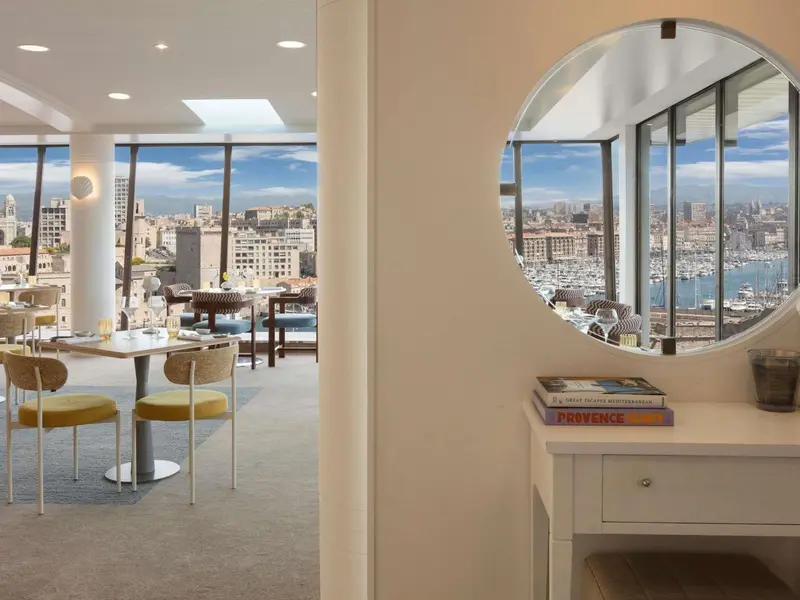 Une salle à manger lumineuse offre une vue panoramique sur la ville et le port.