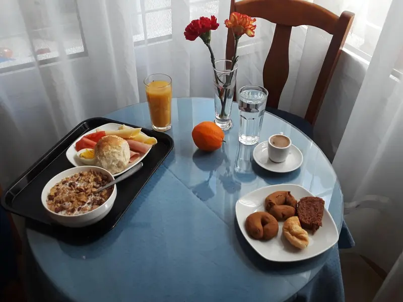 Un petit-déjeuner est servi sur une table ronde recouverte d'une nappe bleue.