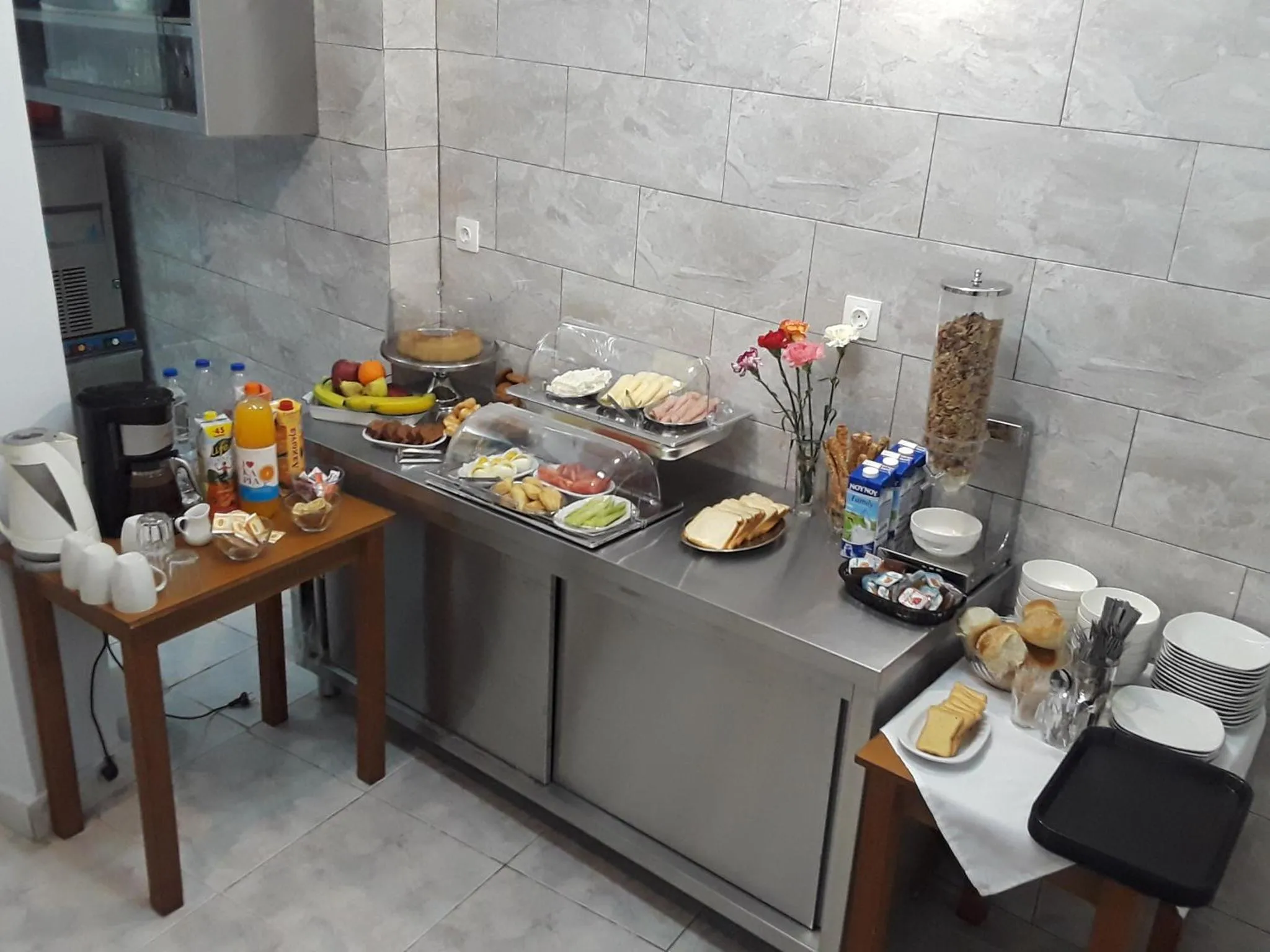 Un buffet propose des viennoiseries, des fruits et des boissons.