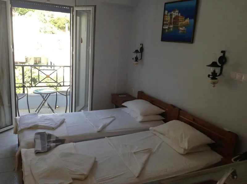 Une chambre lumineuse avec un lit double et un balcon.