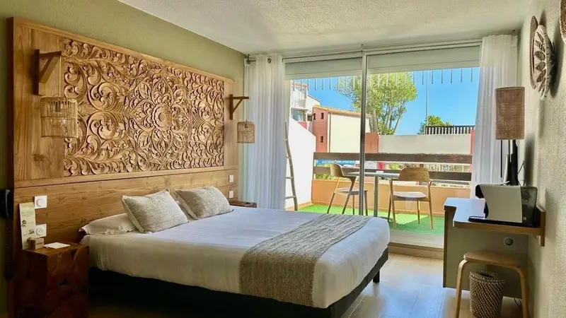 Une chambre lumineuse avec un grand lit et un accès à une terrasse.