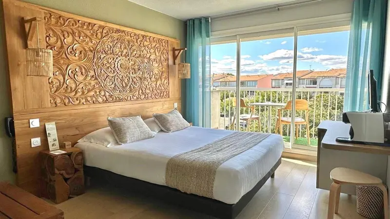 Une chambre lumineuse avec un grand lit et un accès à un balcon.