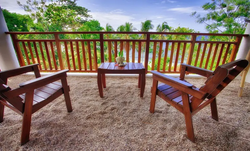 Terrasse en bois avec mobilier de jardin et vue sur la végétation.