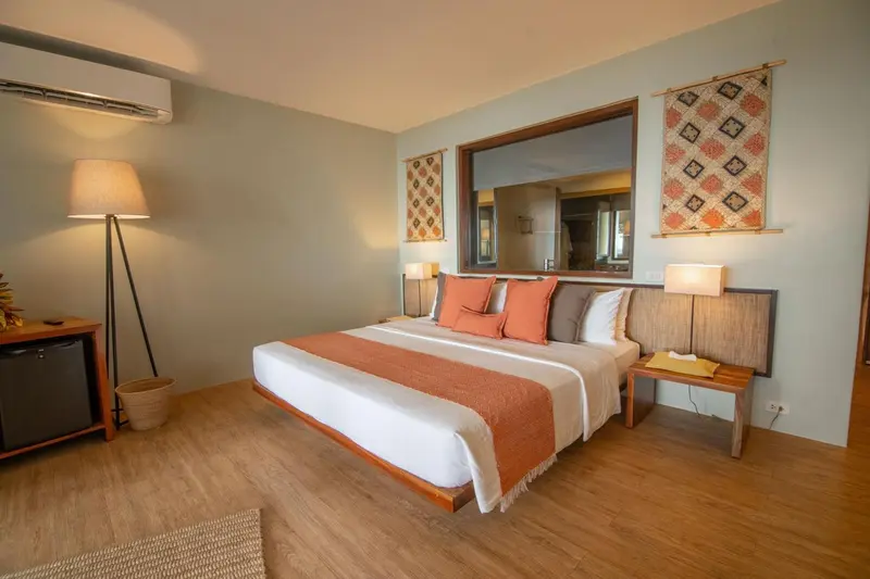 Une chambre lumineuse avec un grand lit et une décoration murale.