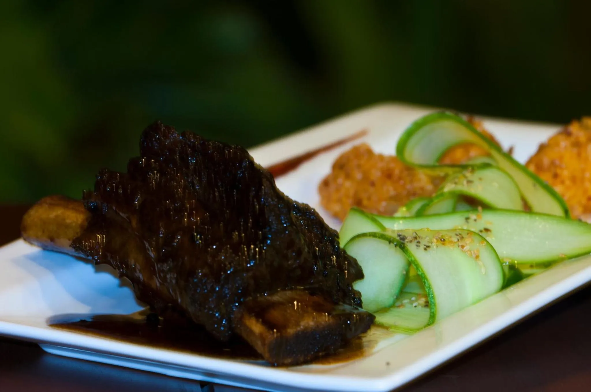 Assiette de viande accompagnée de légumes et d'une sauce.