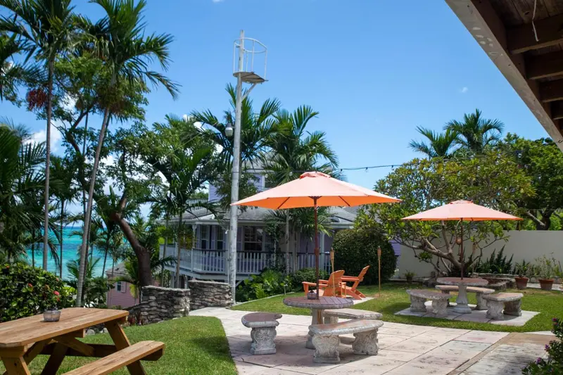 Jardin avec mobilier de détente et parasols colorés.