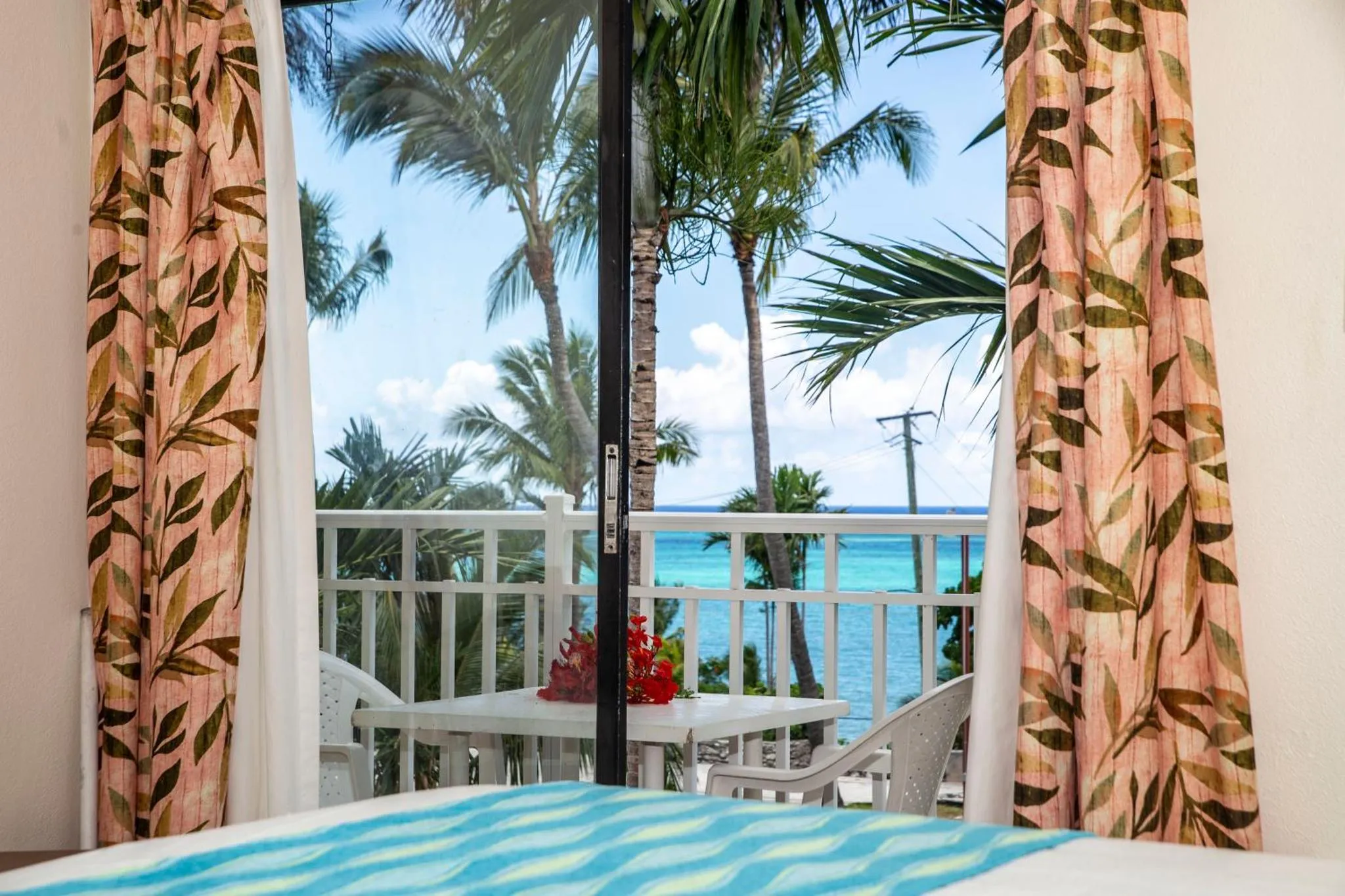 Vue sur la mer depuis une terrasse avec mobilier blanc.