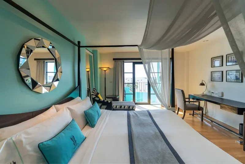 Une chambre lumineuse avec un grand lit et un bureau.