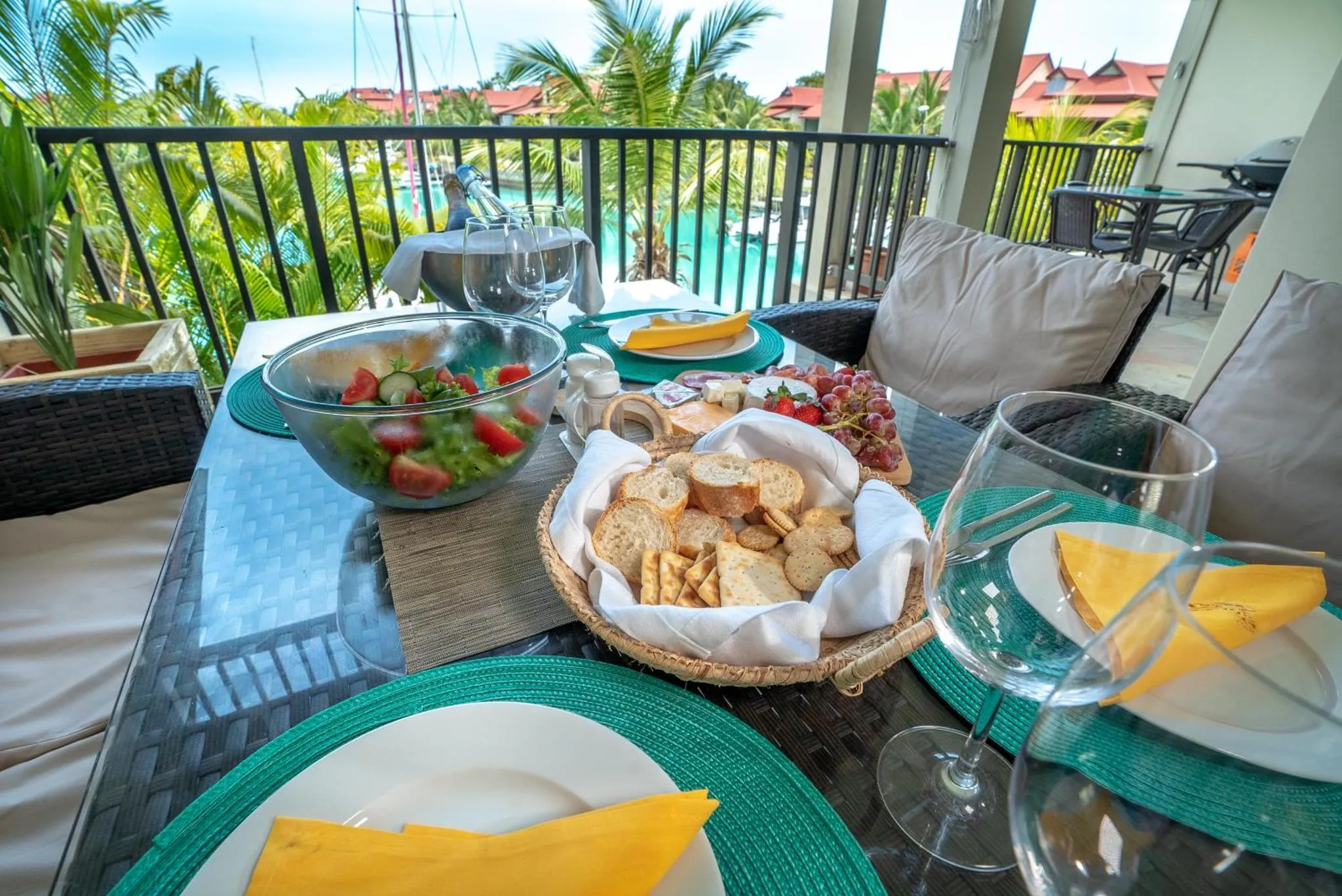 Une table est dressée avec des plats et des boissons sur une terrasse.